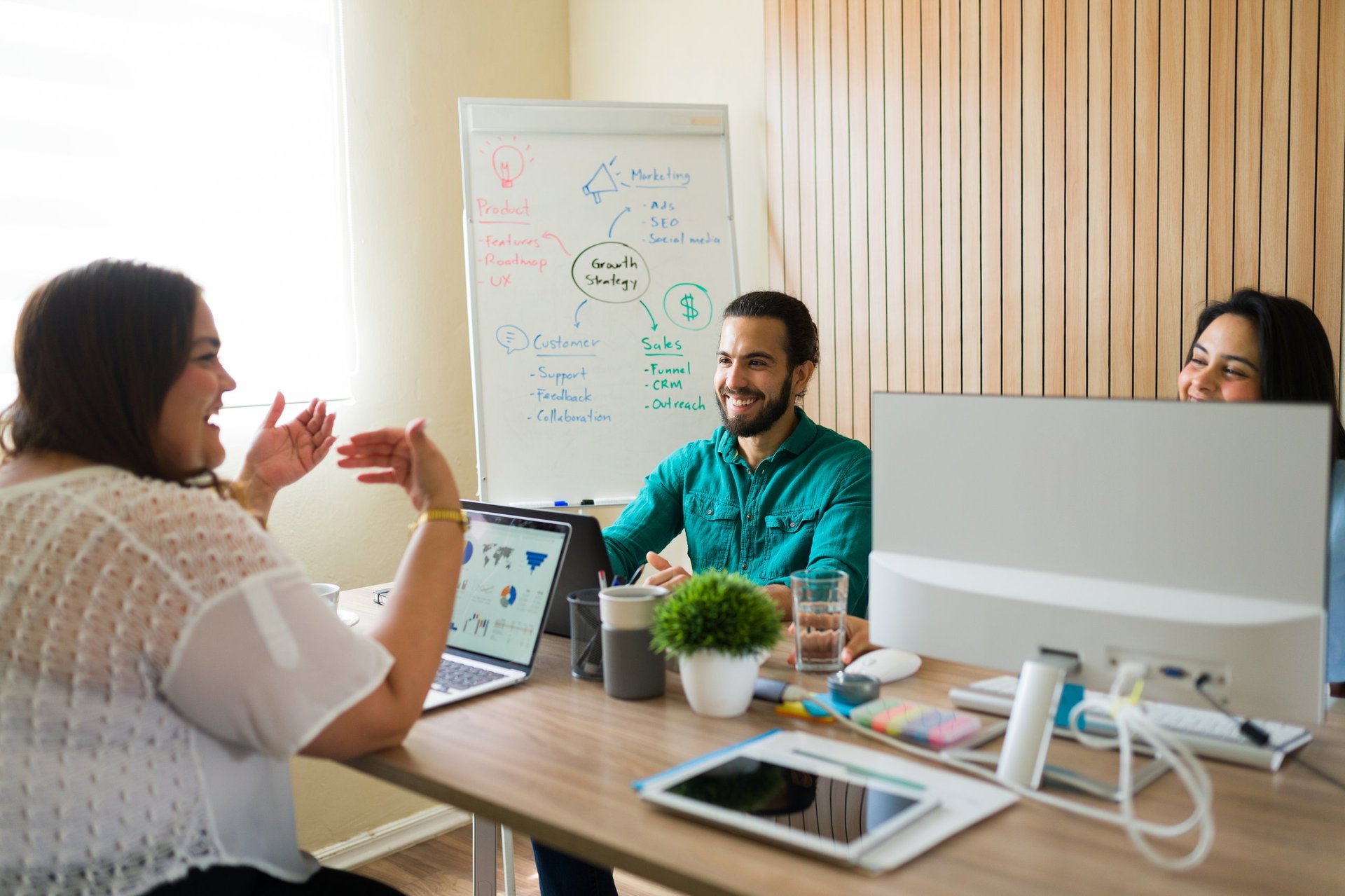 Happy diverse marketing team discussing their business strategy during a productive meeting in modern office workplace
